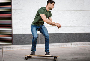 man longboarding in barbell jeans