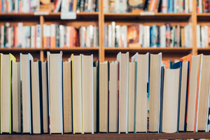 closeup bookshelf with pages of books facing out and more bookshelves in the background